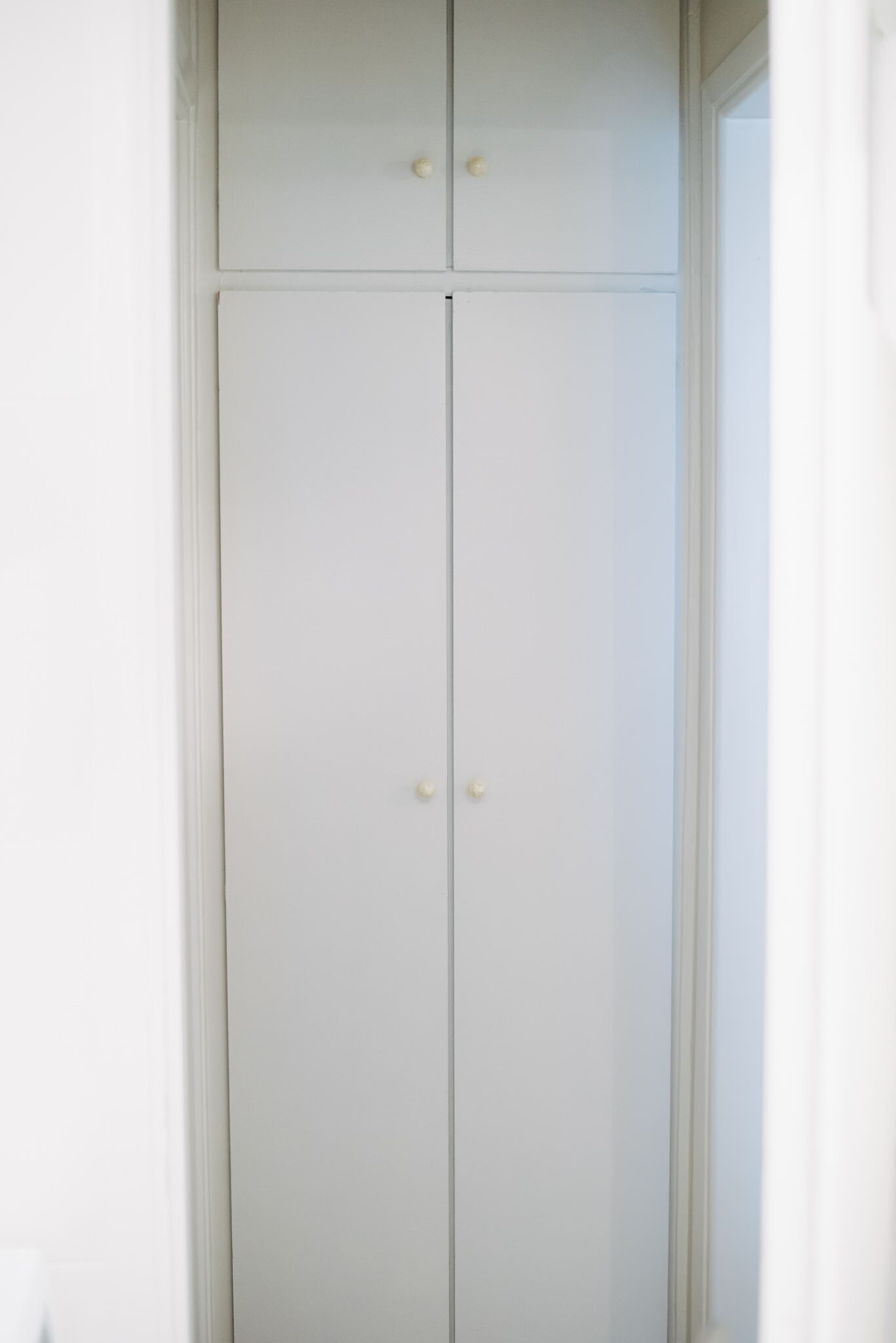 Un armari blanc amb dues portes i dues nassos.