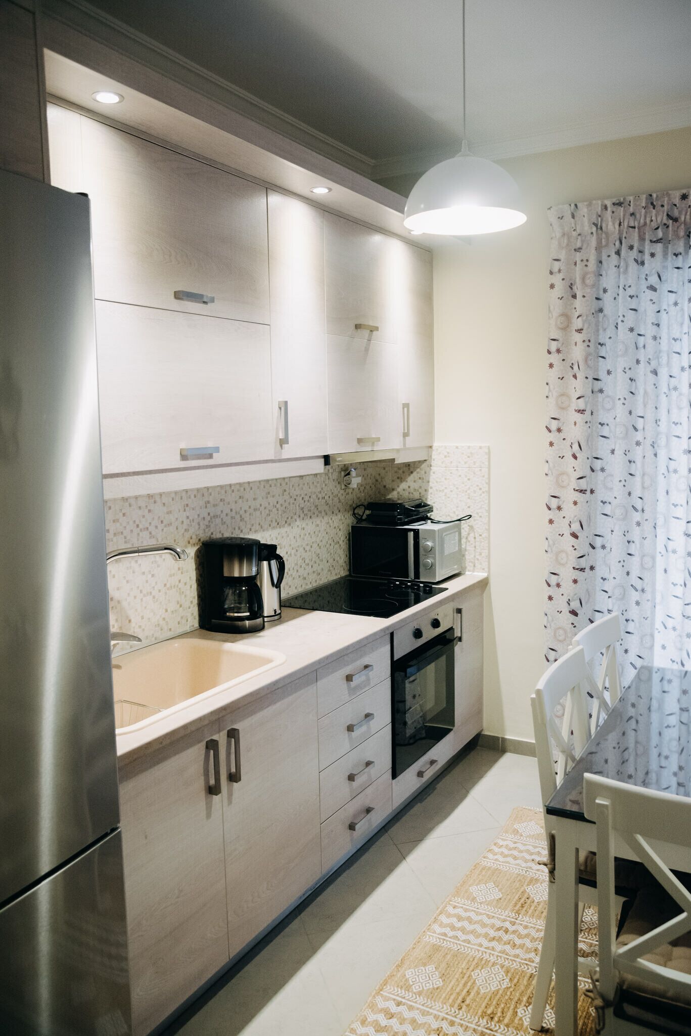 A modern kitchen with stainless steel appliances, a coffee maker, and a microwave.