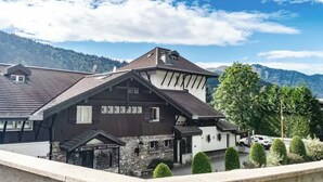 A chalet-style building with a stone foundation, multiple windows, and a sloped roof. - View and Location! (Morzine)