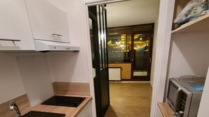 Une cuisine de taille réduite, équipée d’un évier, d’un plan de travail et d’un four à micro-ondes.