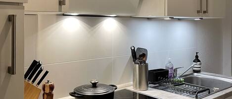 Een koffiezetapparaat/waterkoker, kookgerei, borden en bestek