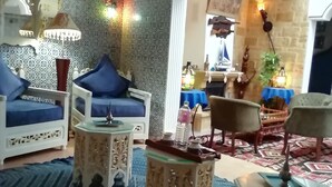 A living room with a patterned wall, a chandelier, and a blue sofa. - Très jolie Riad, style Andalous au centre ville de Bizerte à 10 min de la plage! (Bizerte)