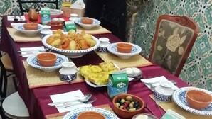 A table set with various dishes, including bowls, plates, and a jug of milk, suggesting a meal setting. - Très jolie Riad, style Andalous au centre ville de Bizerte à 10 min de la plage! (Bizerte)