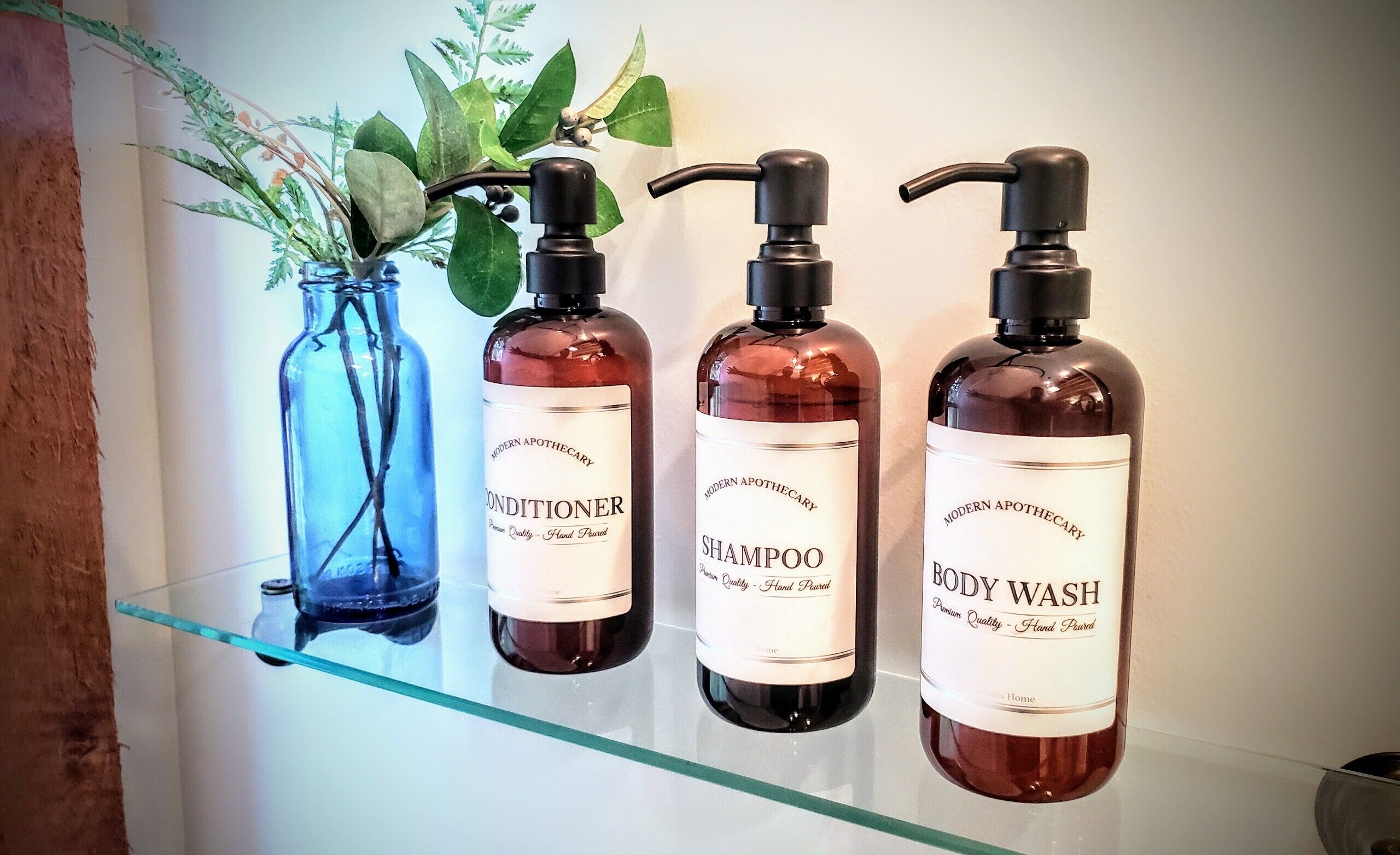 Tre flaconi di prodotti Modern Apothecary su uno scaffale.