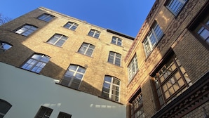 A multi-story building with a brick facade and multiple windows. - cinderella.kreuzberg (Berlin)