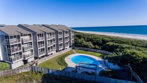 A multi-story hotel with balconies, a swimming pool, and a view of the beach. - Ocean-side condominium with pool and private beach access (Atlantic Beach)