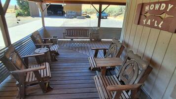 An outdoor wooden deck with seating and a sign reading 'HOWDY YALL'.