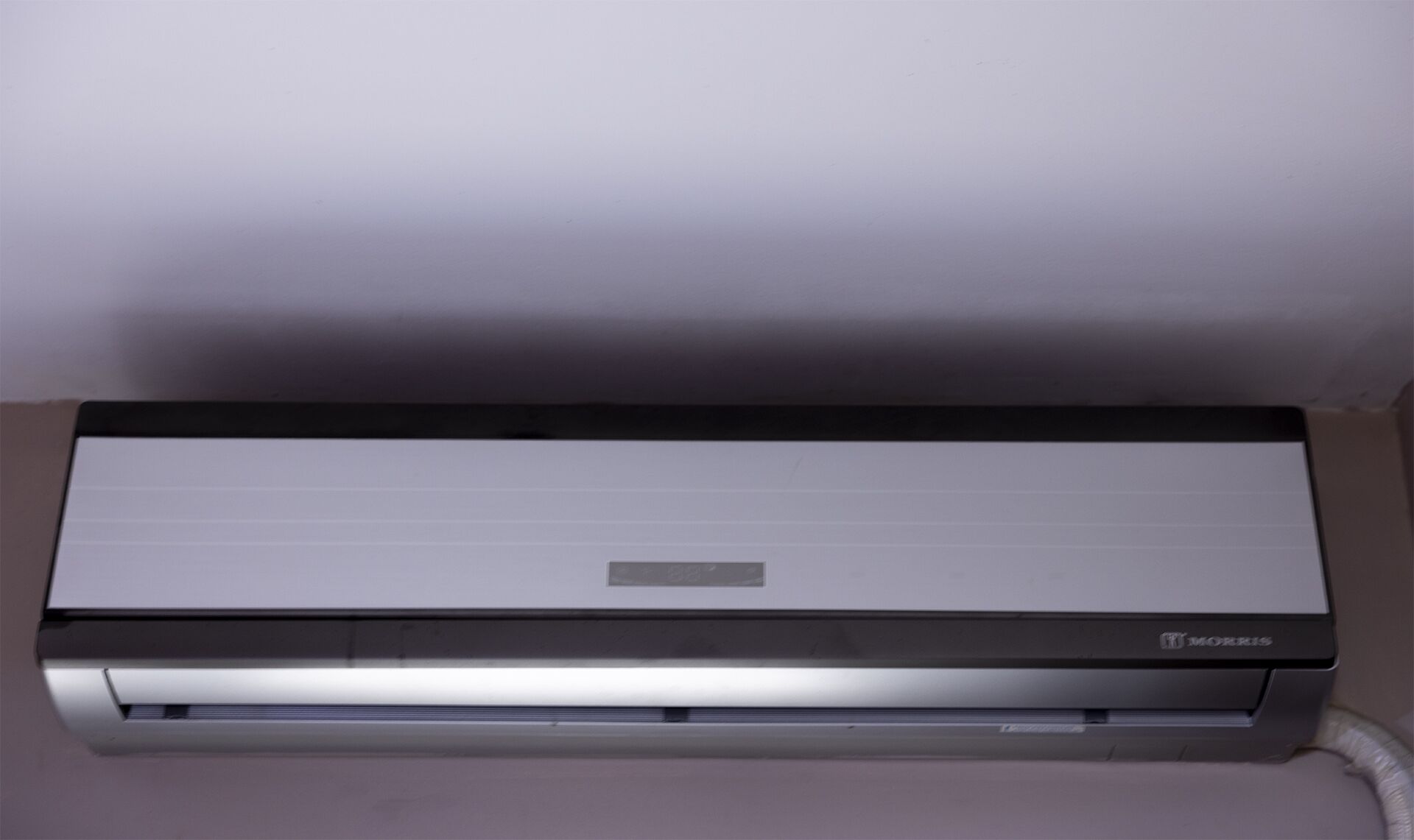 A wall-mounted air conditioning unit with a control panel and a brand name 'Morris'.