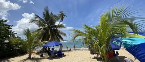 Una playa cerca, sillas reclinables de playa, toallas de playa