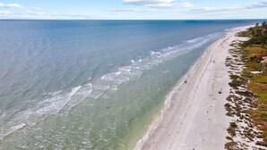 Uma praia com águas claras e areal arenoso.