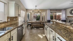 A spacious kitchen with granite countertops, white cabinetry, and a central island. - On HGTV Show House Hunters! Heated Pool! Family & Dog friendly, Prime location!  (Gilbert)