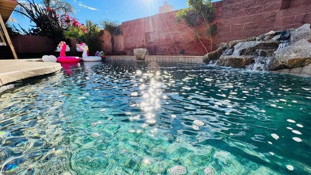A clear pool with a stone wall and a brick wall in the background. - On HGTV Show House Hunters! Heated Pool! Family & Dog friendly, Prime location!  (Gilbert)
