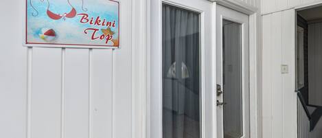 A door with a glass panel and a sign above it that reads "Bikini Top."