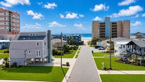A coastal residential area with a paved walkway leading to the beach, surrounded by multi-story buildings. - 8BR/6Ba House, Private Pool, Minute Walk To Beach, Dog Friendly, Sleeps 24 (North Myrtle Beach)