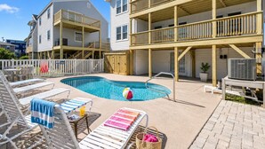 A residential building with a swimming pool, outdoor seating, and a wooden deck. - 8BR/6Ba House, Private Pool, Minute Walk To Beach, Dog Friendly, Sleeps 24 (North Myrtle Beach)