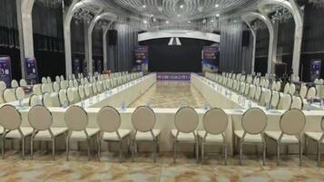A conference room with a long table, multiple chairs, and banners.