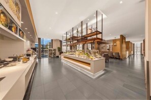 A modern hotel lobby with a central island, seating area, and a reception desk.