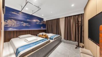 A hotel room with a large bed, a desk, a chair, a TV, and a wall with a painting.