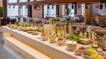 Montaje de buffet con diversos alimentos y recipientes de vidrio.