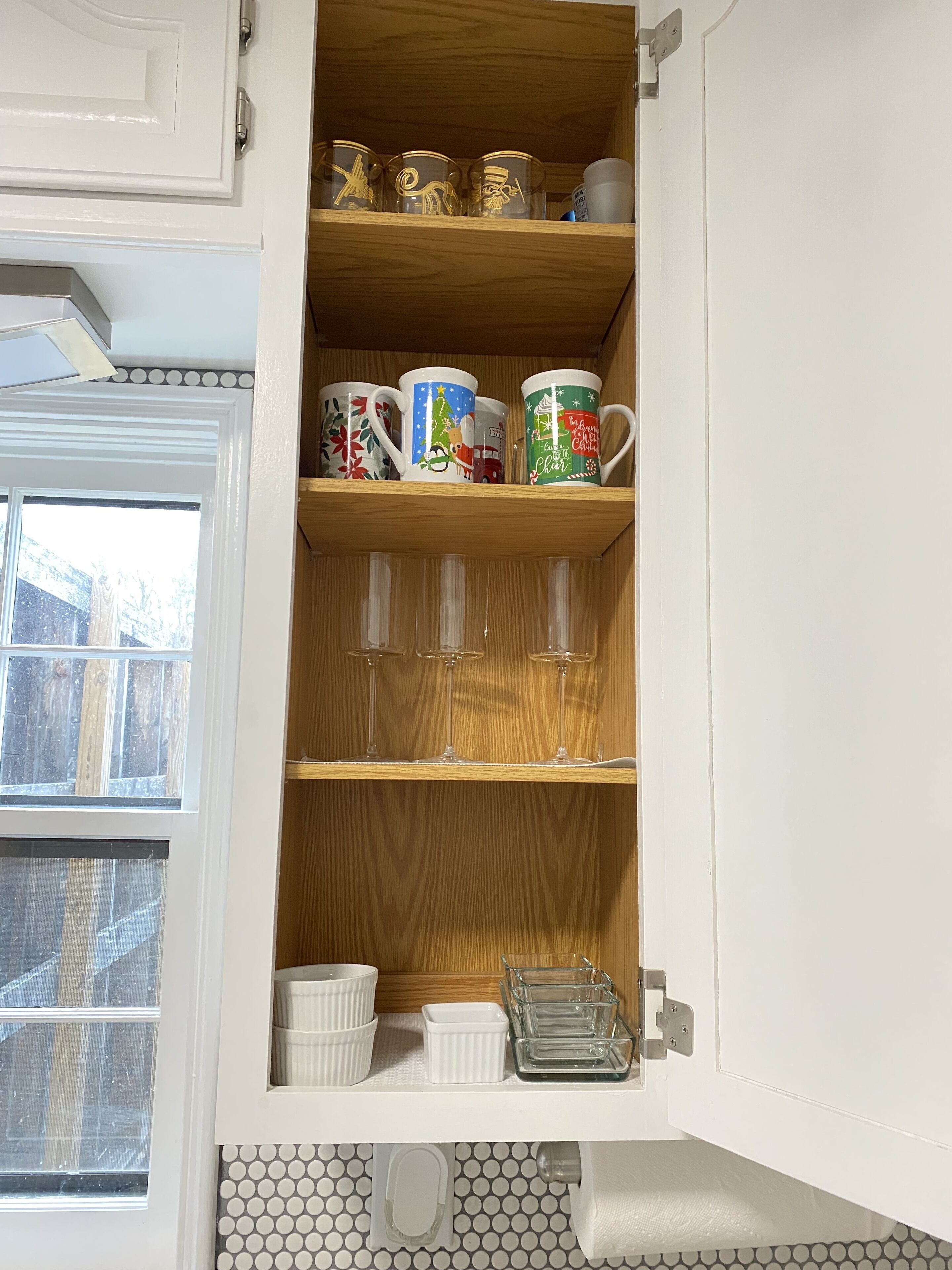 Un meuble de cuisine contenant divers objets, notamment des tasses, des verres et des récipients.