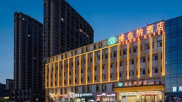 A hotel with a modern facade, multiple floors, and a prominent sign.