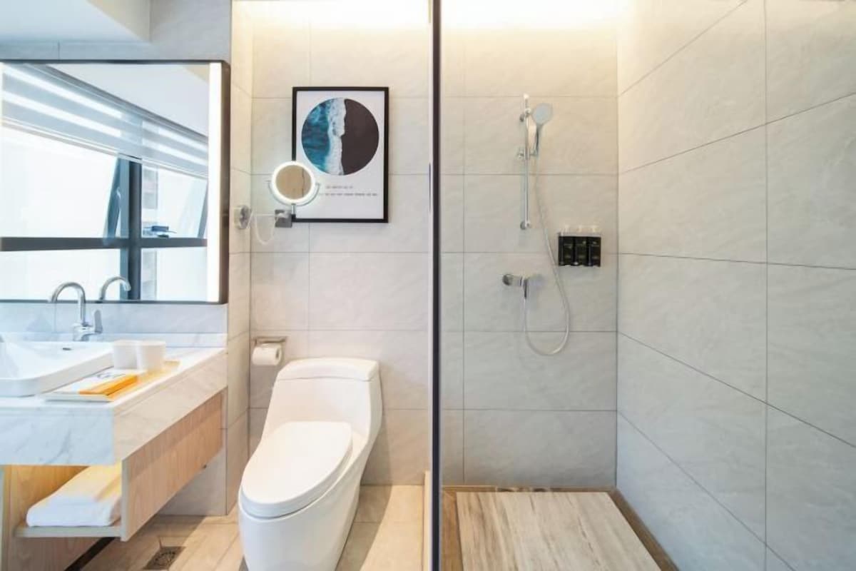A modern bathroom with a toilet, sink, and shower.