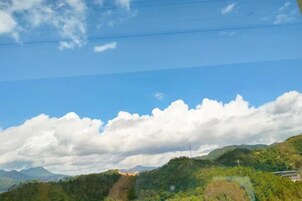 Un paisaje montañoso con cielo despejado y nubes dispersas.