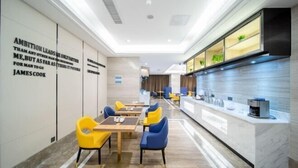 A modern dining area with yellow and blue chairs, a long counter with a coffee machine, and motivational quotes on the wall. - Kyriad Hotel (Zijin Wanhui Branch) (Zijin)