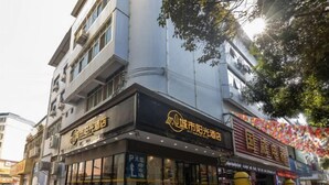 A hotel with a modern facade, large windows, and a visible entrance. - City Express Hotel (Longzhou)