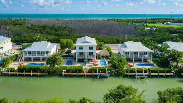 Un resort con varias construcciones, una piscina y vista al océano.