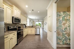 Enjoy cooking in this well-equipped kitchen with a refrigerator, microwave, and oven, and take in the garden view.
