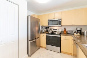 Enjoy cooking in this well-equipped kitchen with a refrigerator, oven, and microwave.
