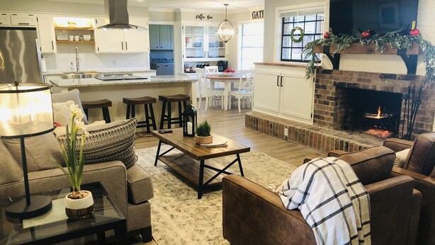 Una sala de estar moderna con chimenea, un comedor y una cocina.