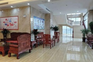 A spacious lobby with a polished floor, wooden furniture, and a staircase leading to an upper level. - Manshanhong International Hotel (Quanzhou)