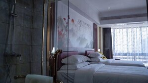 Quarto de hotel com cama, chuveiro e uma janela grande.
