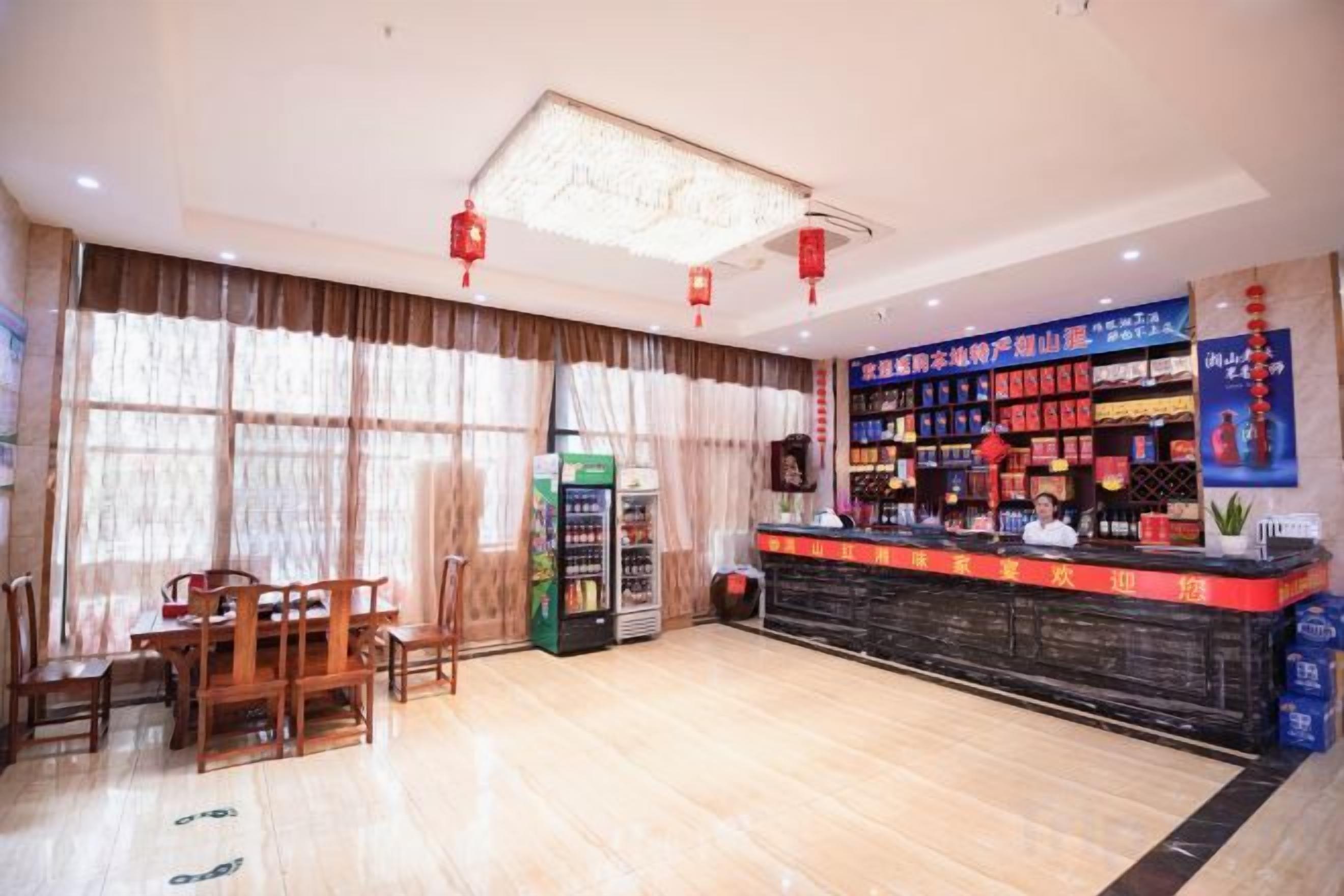 A hotel lobby with a reception desk, vending machines, and a seating area.