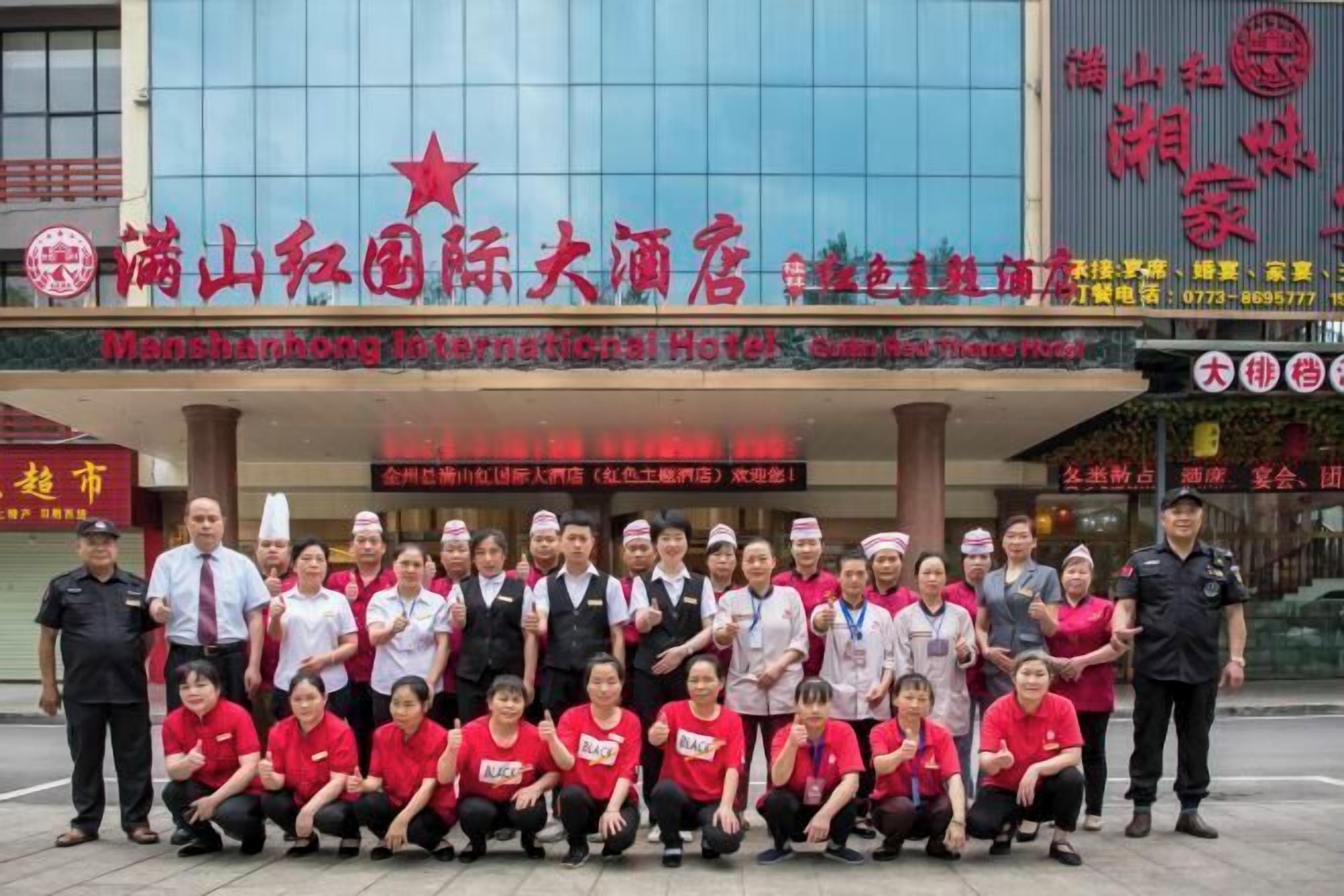 A group of hotel staff in front of the Manzhouhong International Hotel.