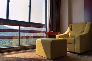 A room with a large window, a sofa, and a small table. - Manshanhong International Hotel (Quanzhou)