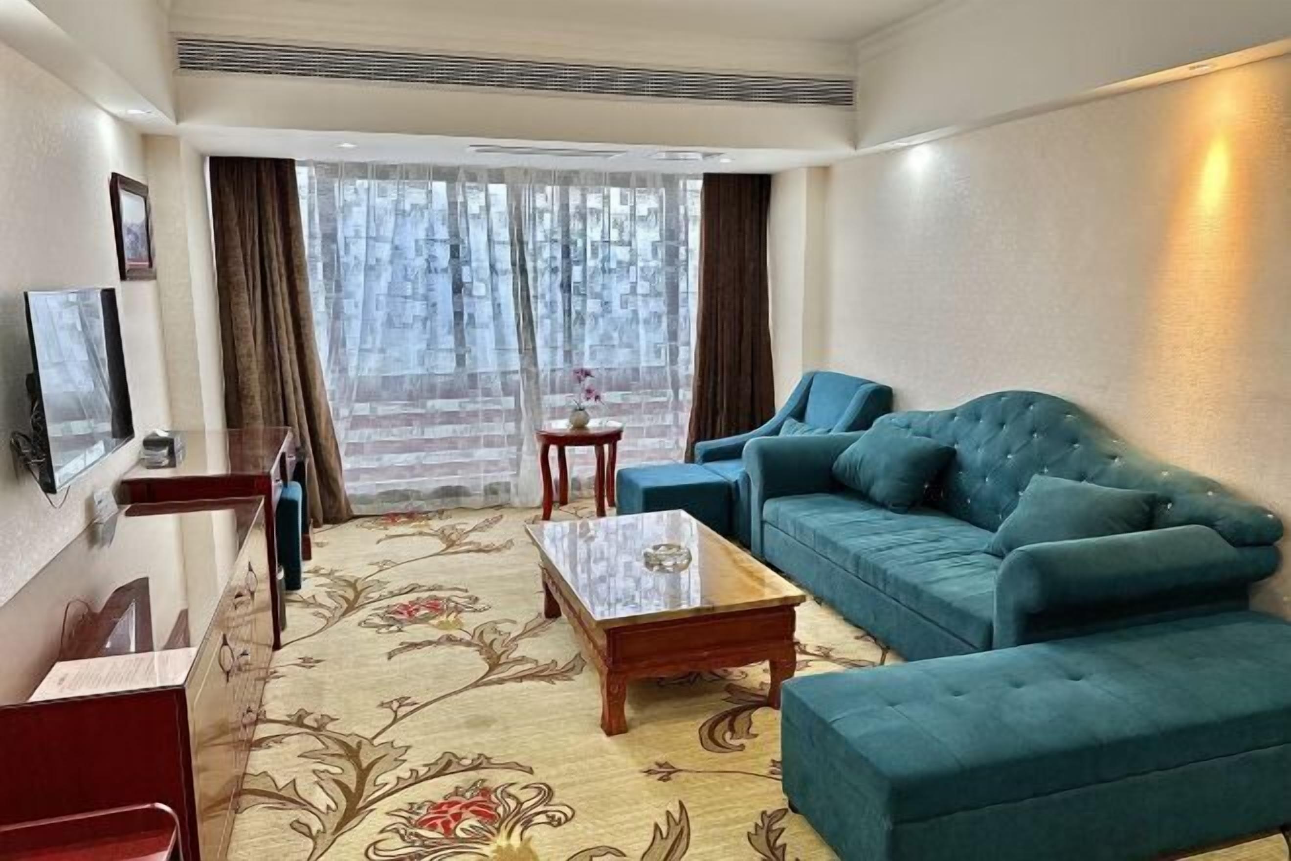 A living room with a sofa, a coffee table, and a TV.