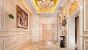A grand hallway with a large chandelier, a painting on the wall, and a decorative floor pattern. - Vienna Hotel (Jiujiang Duchangxin Bus Station) (Duchang)