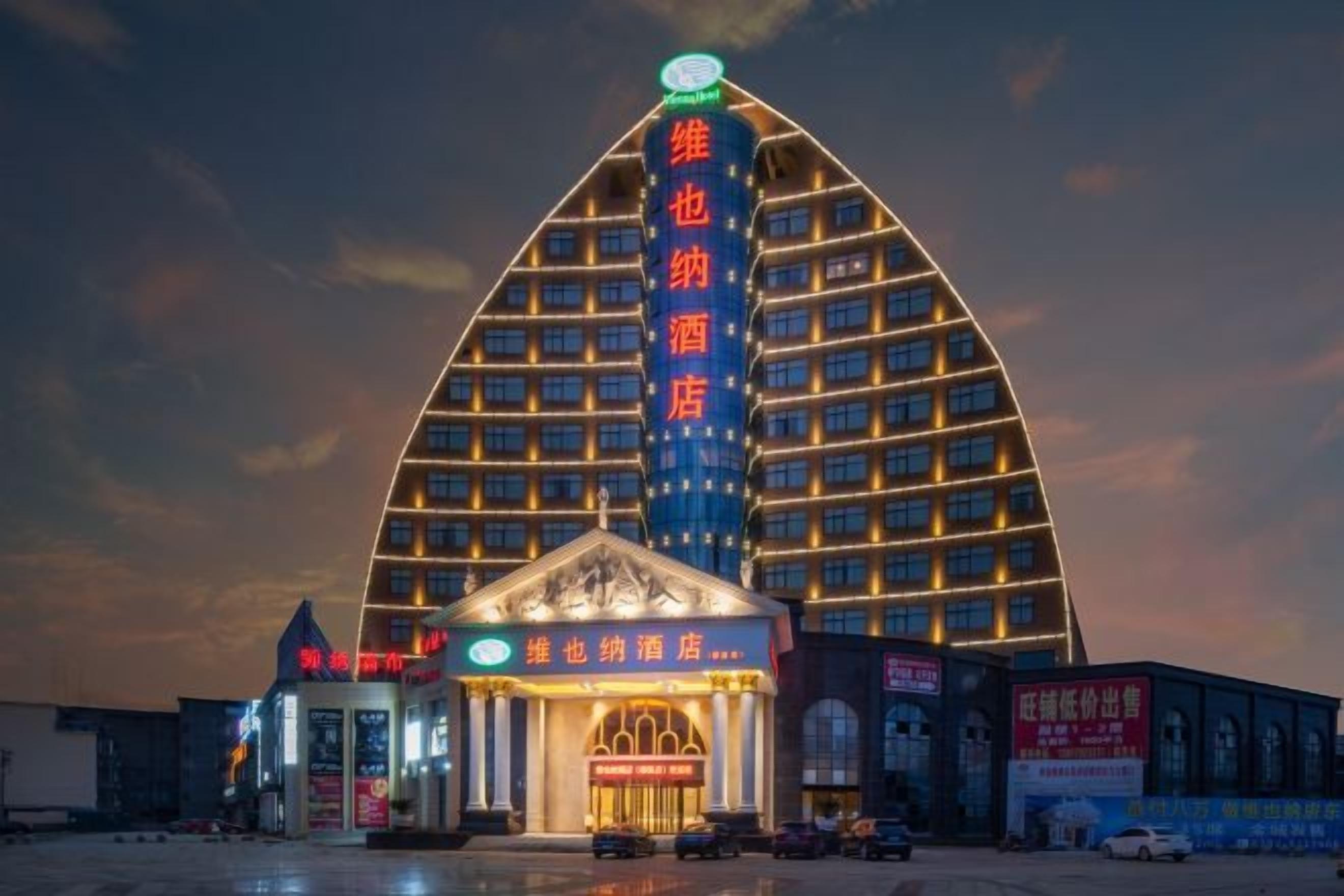 A hotel with a distinctive triangular roof structure and a central entrance with a marquee.
