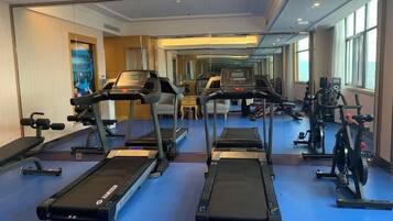A hotel gym with treadmills, stationary bikes, and weight machines.