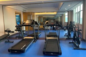 A hotel gym with treadmills, stationary bikes, and weight machines. - Vienna Hotel (Jiujiang Duchangxin Bus Station) (Duchang)