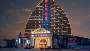 A hotel with a distinctive triangular facade and a central entrance with a marquee sign. - Vienna Hotel (Jiujiang Duchangxin Bus Station) (Duchang)
