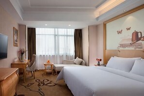 A hotel room with a bed, a desk, a chair, a small table, a TV, and a large window with curtains. - Vienna Hotel (Jiujiang Duchangxin Bus Station) (Duchang)