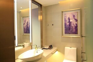 A modern bathroom with a large mirror, a sink, and a toilet. - Lavande Hotel (Foshan)