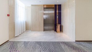 A modern elevator in a hallway with a patterned carpet and light-colored walls. - Lavande Hotel (Foshan South Railway Station Bijiang Light Rail Station) (Foshan)