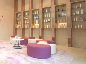 A modern interior with seating areas and display shelves. - Lavande Hotel (Foshan)