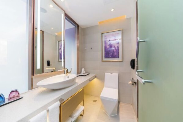 A modern bathroom with a large mirror, a sink, a toilet, and a shower. - Lavande Hotel (Foshan)