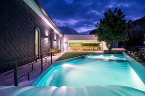 Une piscine avec un bâtiment moderne en arrière-plan.